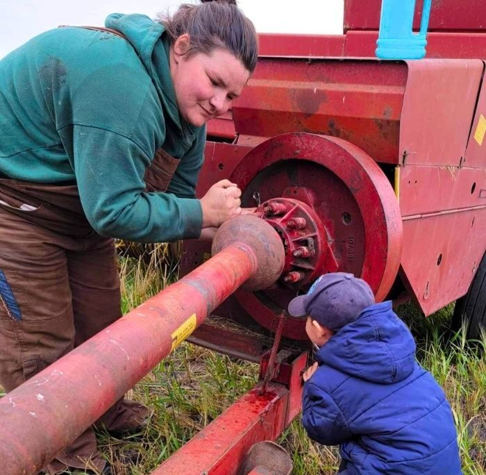 Mom and son working on baler